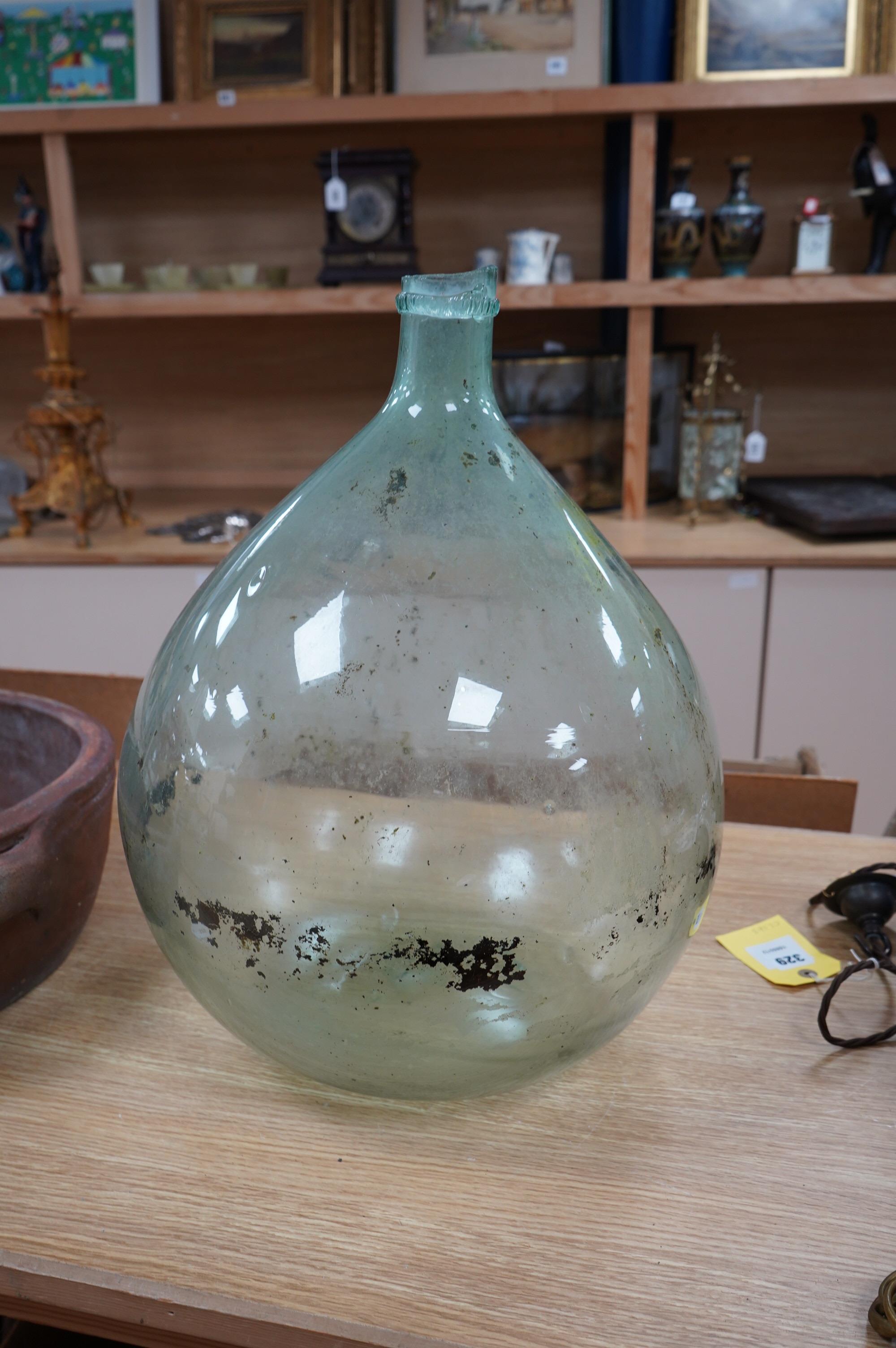 A large glass globular bottle, 48cm high. Condition - poor, significant staining and chipping to rim.